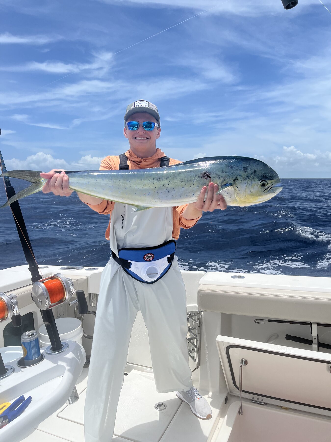 Angler holding a mahi caught aboard Deli's Dream